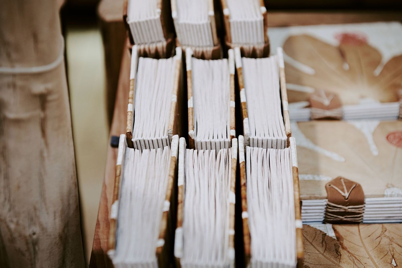 Nahaufnahme handgebundener Bücher mit sichtbaren Papierlagen und Fäden